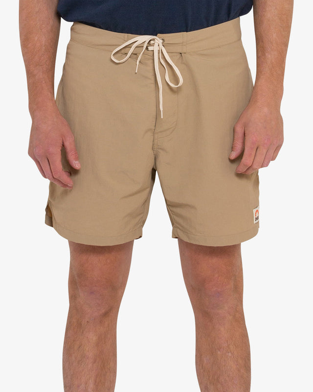 tan 16 inch leg fixed waist boards short with back flap pocket, branded woven label at front hem, 95% nylon 5% elastane water resistant fabrication with a garment wash