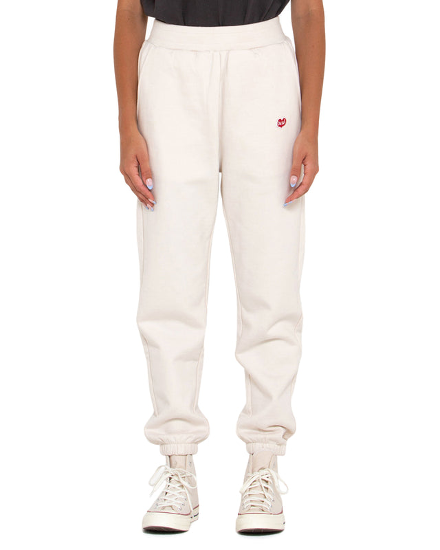 white relaxed fit track pant with front embroidered badge, elasticated drawstring waist, 100% organic cotton 450gm brushed back fleece fabrication with a heavy enzyme stone wash