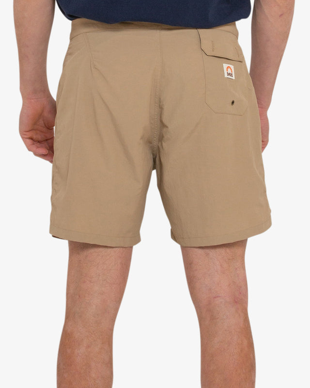 tan 16 inch leg fixed waist boards short with back flap pocket, branded woven label at front hem, 95% nylon 5% elastane water resistant fabrication with a garment wash