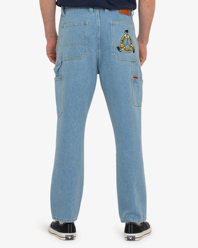 light indigo relaxed fit pant with zip fly and shank button closure, embroidered artwork on back pocket, branded leather patch in a 100% cotton denim twill fabrication